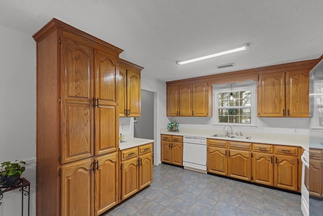 kitchen with sink, a textured ceiling, and white appliances