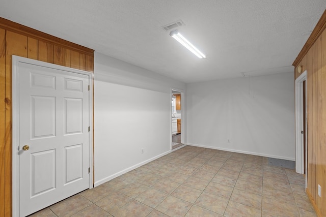 tiled empty room with a textured ceiling