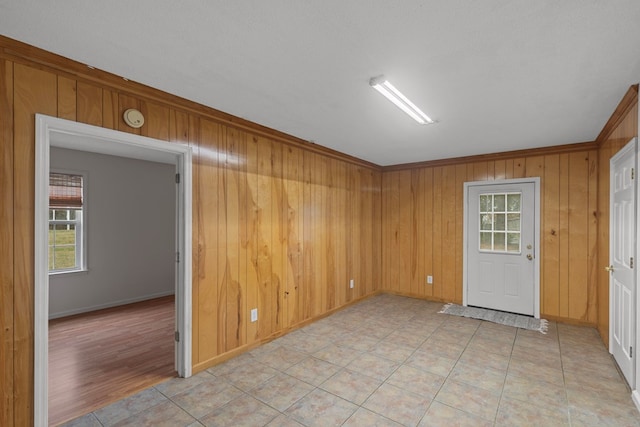 spare room with light tile patterned floors and wood walls