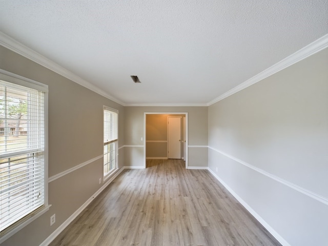 unfurnished room featuring crown molding, plenty of natural light, a textured ceiling, and light hardwood / wood-style flooring