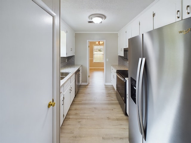 kitchen featuring white cabinets, light wood-type flooring, ornamental molding, appliances with stainless steel finishes, and tasteful backsplash