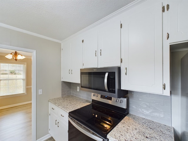 kitchen with backsplash, white cabinetry, stainless steel appliances, and light hardwood / wood-style flooring