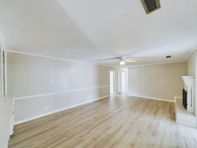 unfurnished living room featuring a brick fireplace, light hardwood / wood-style flooring, and crown molding