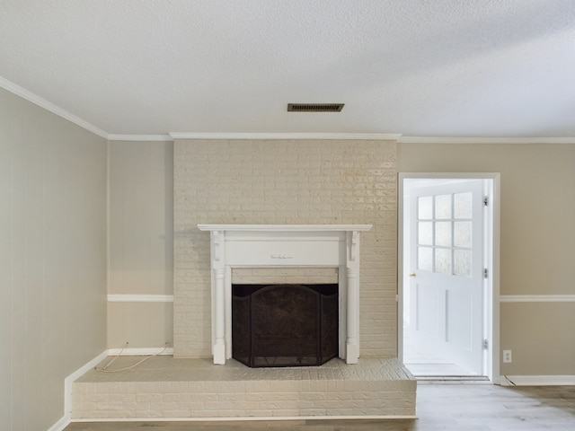 interior details with hardwood / wood-style flooring, a textured ceiling, crown molding, and a brick fireplace