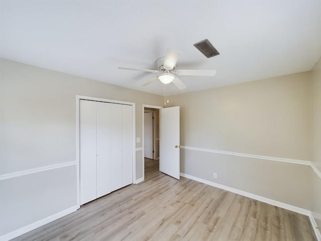 unfurnished bedroom featuring ceiling fan, a closet, and light hardwood / wood-style flooring