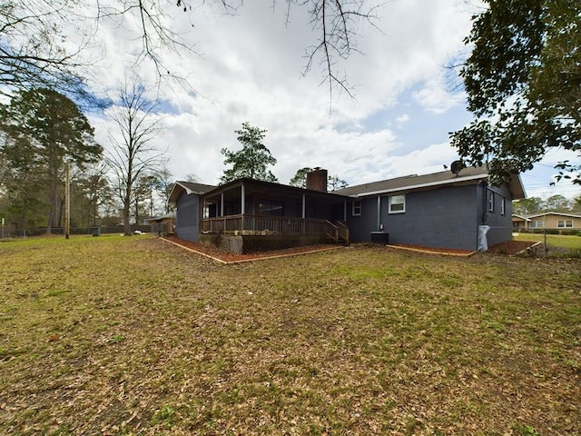 exterior space with central AC, a sunroom, and a yard