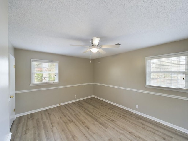 empty room featuring ceiling fan, a textured ceiling, and light hardwood / wood-style flooring