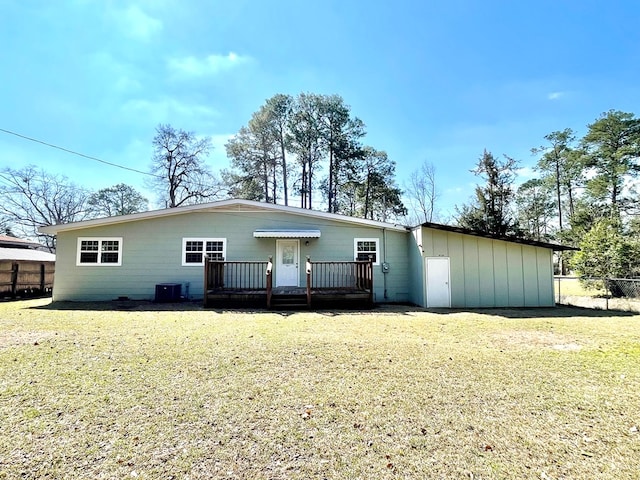 back of house featuring a deck, a lawn, and fence