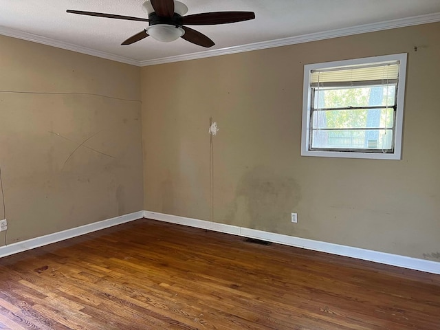 spare room with crown molding, dark wood-type flooring, and ceiling fan