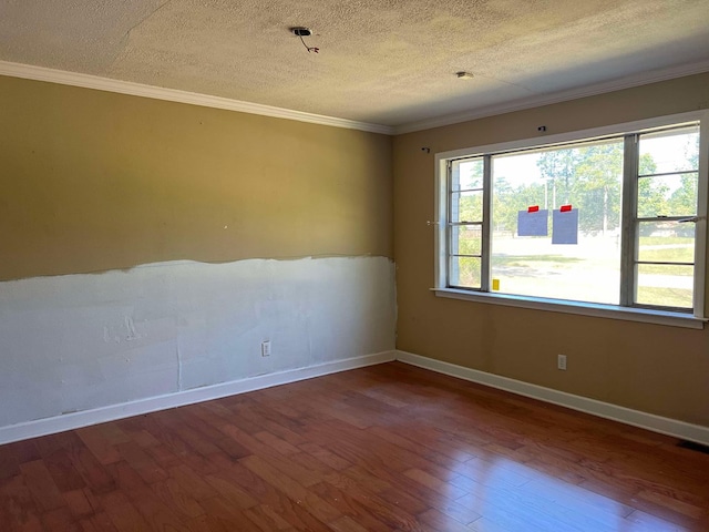 empty room with crown molding, hardwood / wood-style floors, and a textured ceiling