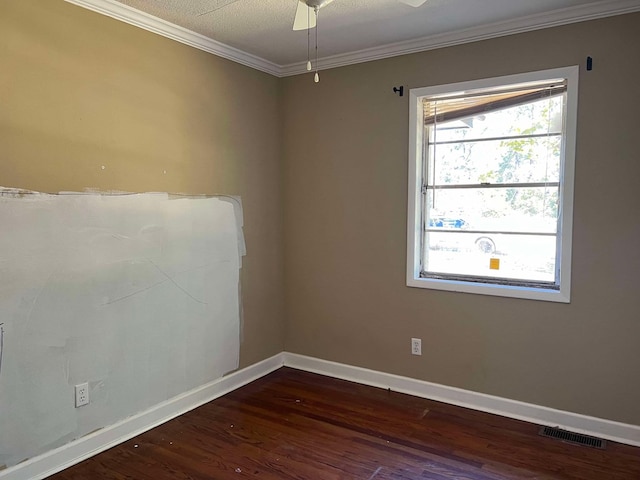 empty room with dark hardwood / wood-style flooring, ornamental molding, and ceiling fan