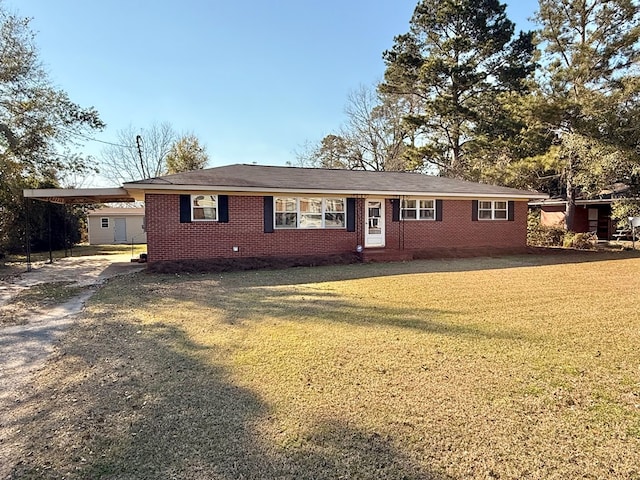 ranch-style home featuring a carport, concrete driveway, brick siding, and a front lawn