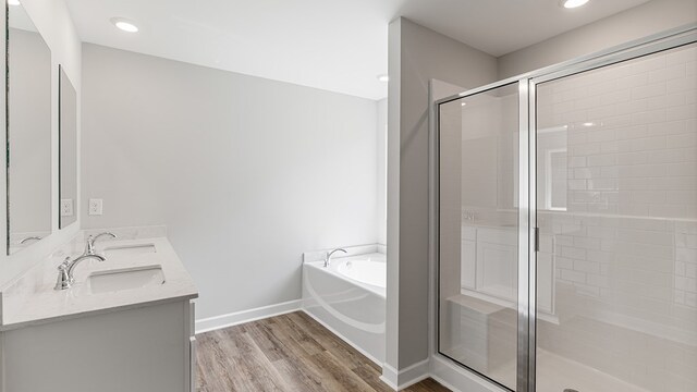 bathroom with hardwood / wood-style floors, vanity, and independent shower and bath