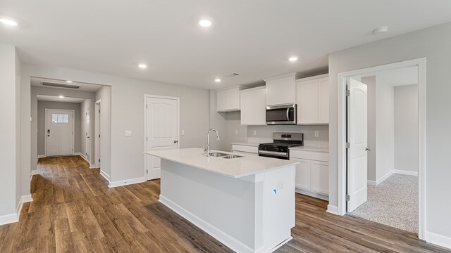 kitchen with white cabinetry, a kitchen island with sink, sink, and stainless steel appliances