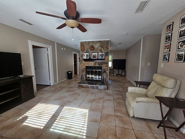 living room with a textured ceiling, a ceiling fan, and visible vents