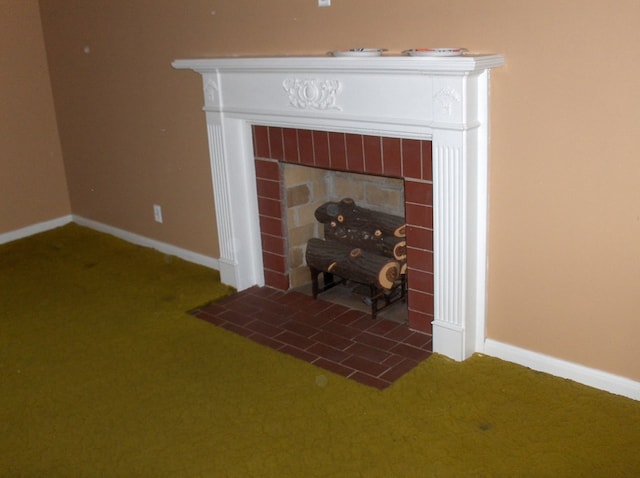 interior details with baseboards, carpet floors, and a tile fireplace