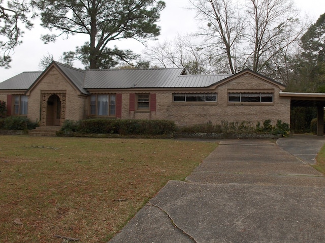 ranch-style house with brick siding, metal roof, an attached carport, and a front lawn