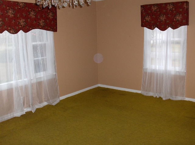 carpeted spare room featuring baseboards