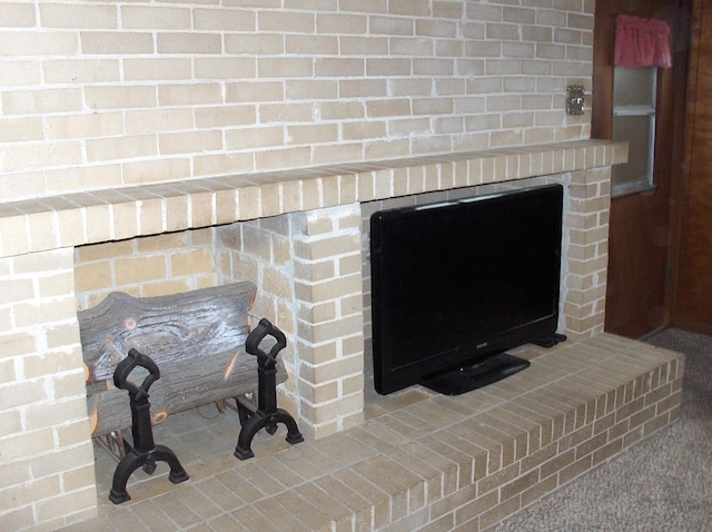 interior details featuring a brick fireplace