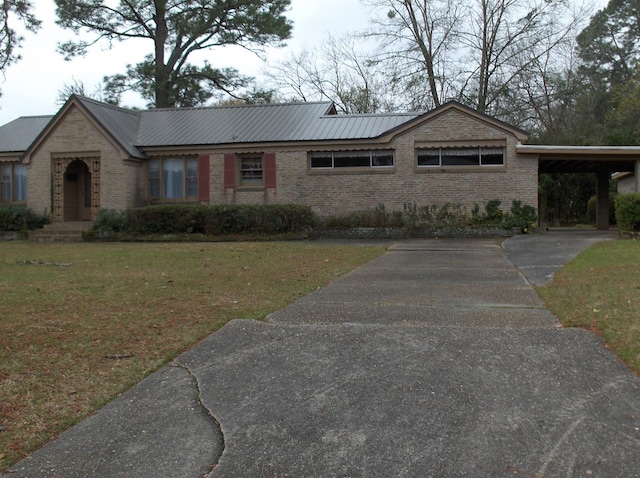 single story home with an attached carport, a front yard, brick siding, and metal roof