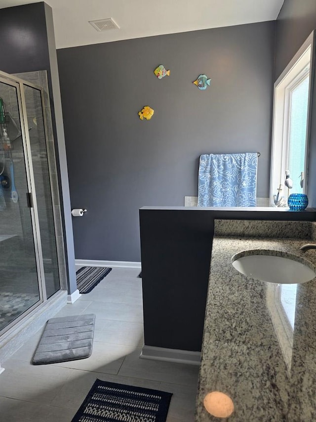 bathroom with tile patterned floors, vanity, and an enclosed shower