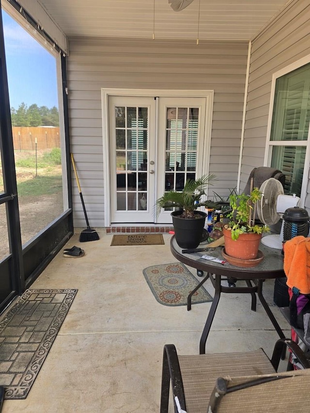 sunroom / solarium with ceiling fan and french doors