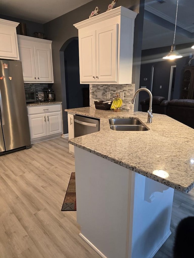 kitchen featuring backsplash, stainless steel appliances, sink, white cabinets, and a breakfast bar area