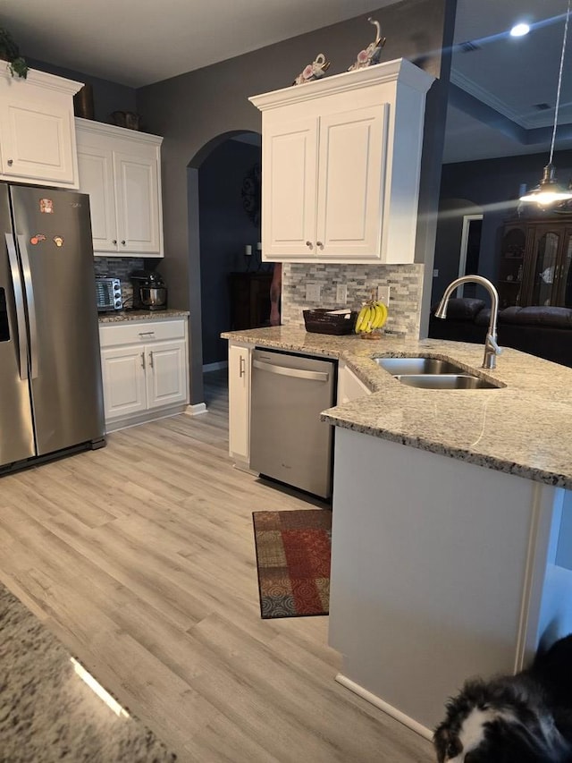 kitchen with white cabinetry, sink, light hardwood / wood-style flooring, decorative backsplash, and appliances with stainless steel finishes