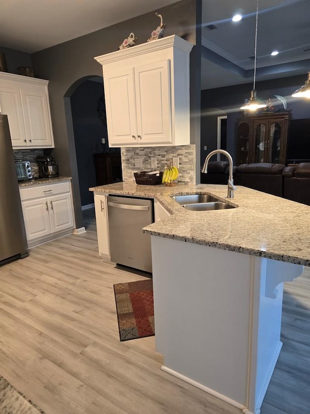 kitchen featuring sink, stainless steel appliances, backsplash, white cabinets, and light wood-type flooring