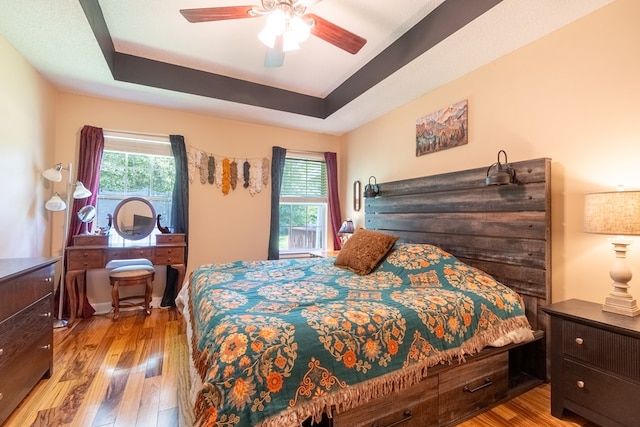 330 Brushfire Dr, Dothan, AL 36305 - bedroom with multiple windows, wood finished floors, a tray ceiling, and a ceiling fan