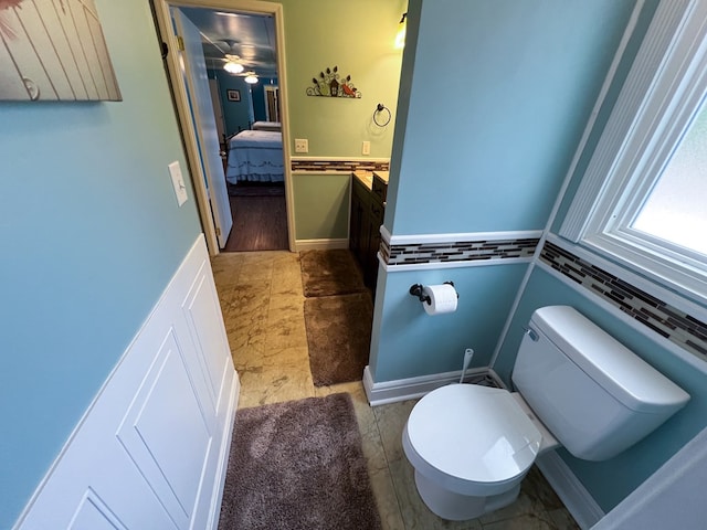 bathroom with ensuite bath, toilet, and vanity