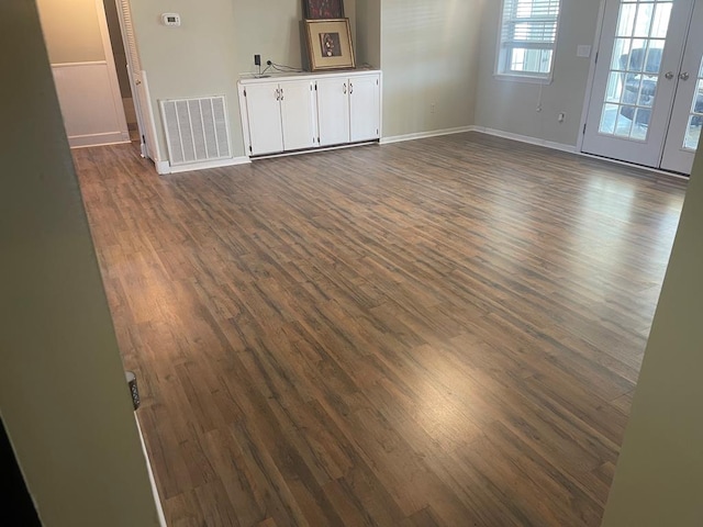 spare room with visible vents, baseboards, and dark wood-style floors