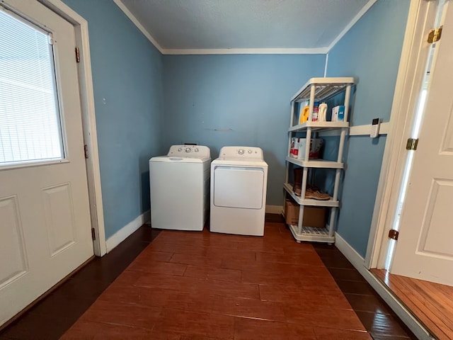 clothes washing area with crown molding, dark wood-type flooring, baseboards, laundry area, and washer and dryer