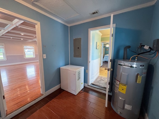 utility room with electric panel, visible vents, and water heater