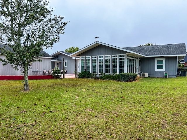 rear view of house with a yard and central AC unit