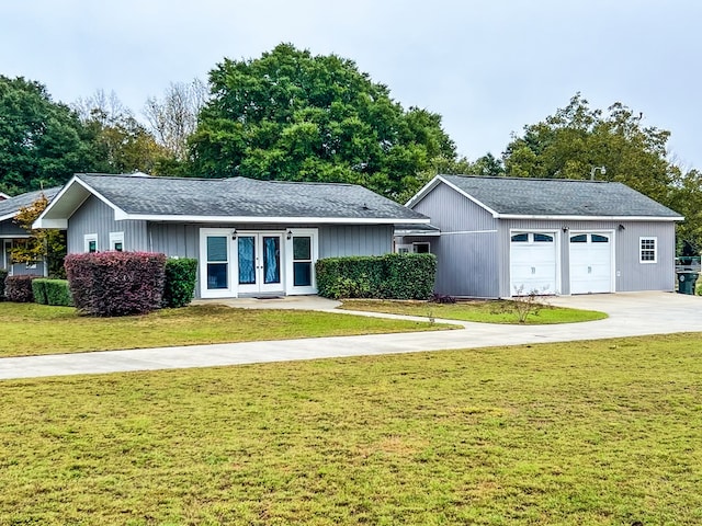 single story home featuring a front yard, roof with shingles, an attached garage, concrete driveway, and french doors