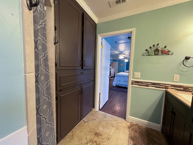 full bath with visible vents, crown molding, baseboards, vanity, and ensuite bath