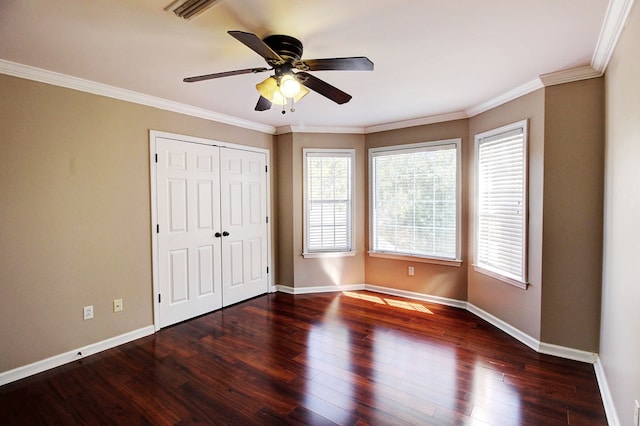 unfurnished bedroom featuring ceiling fan, ornamental molding, dark wood-type flooring, and a closet