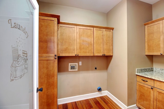 laundry room with hookup for an electric dryer, cabinets, wood-type flooring, and hookup for a washing machine