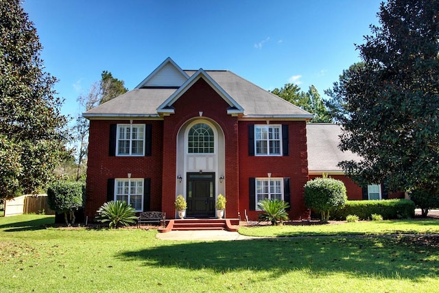 colonial-style house featuring a front lawn