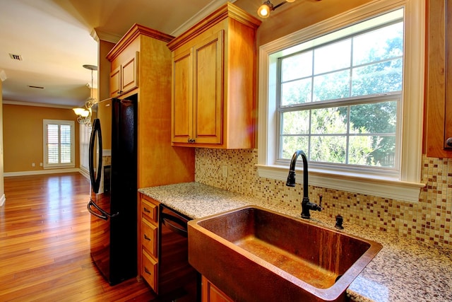 kitchen featuring black appliances, a healthy amount of sunlight, and tasteful backsplash