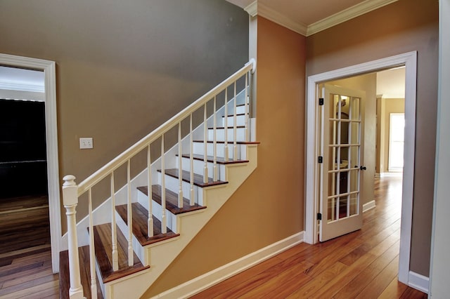 stairs with crown molding and hardwood / wood-style floors