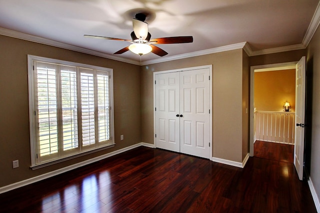 unfurnished bedroom featuring ceiling fan, crown molding, dark wood-type flooring, and a closet