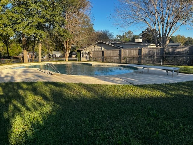 view of swimming pool featuring a diving board and a yard