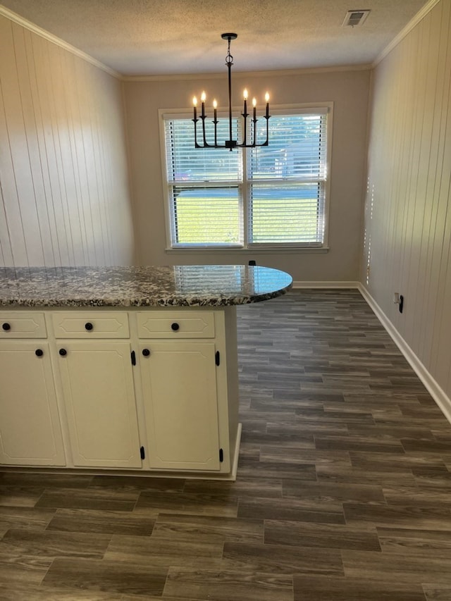 interior space featuring light stone countertops, decorative light fixtures, white cabinets, a chandelier, and dark hardwood / wood-style floors