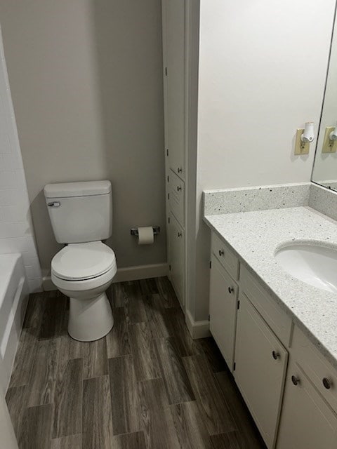 bathroom with hardwood / wood-style floors, vanity, and toilet