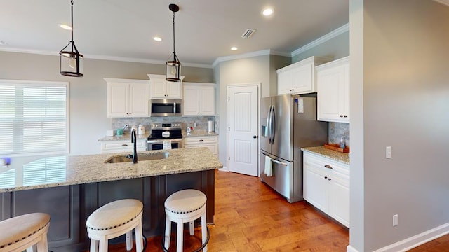 kitchen featuring decorative light fixtures, stainless steel appliances, and a wealth of natural light