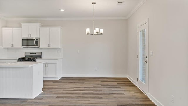 109 Creekridge St, Headland, AL 36345 - kitchen with wood finished floors, white cabinets, light countertops, appliances with stainless steel finishes, and a chandelier
