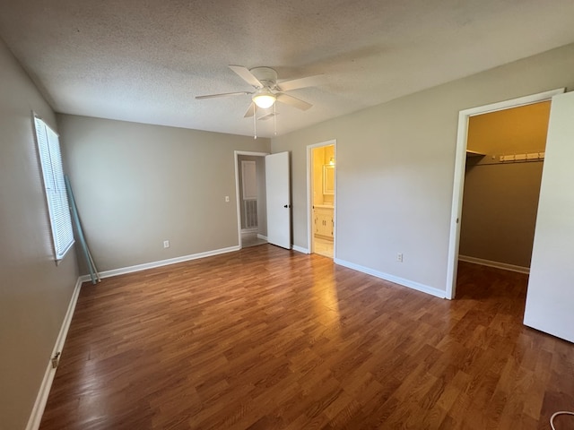 411 Kentworth Dr, Dothan, AL 36301 - unfurnished bedroom with a walk in closet, wood finished floors, a textured ceiling, ceiling fan, and ensuite bath