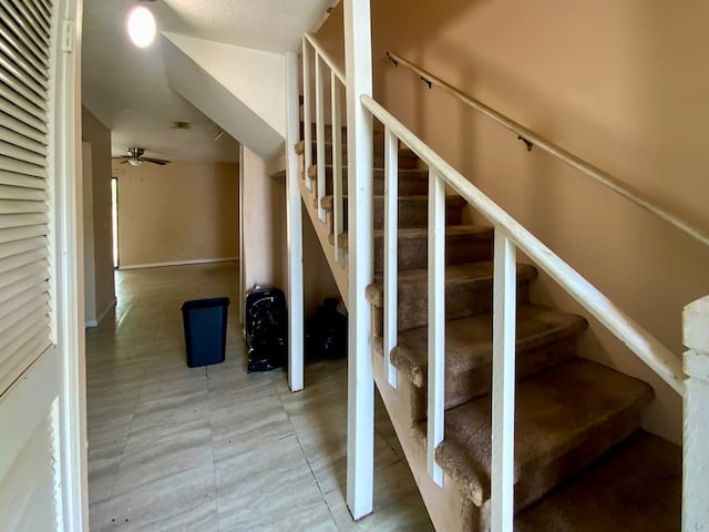 staircase featuring ceiling fan